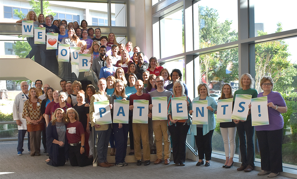 CCMH Employees gathered for Hospital week with "We Love Our Patients!" signs