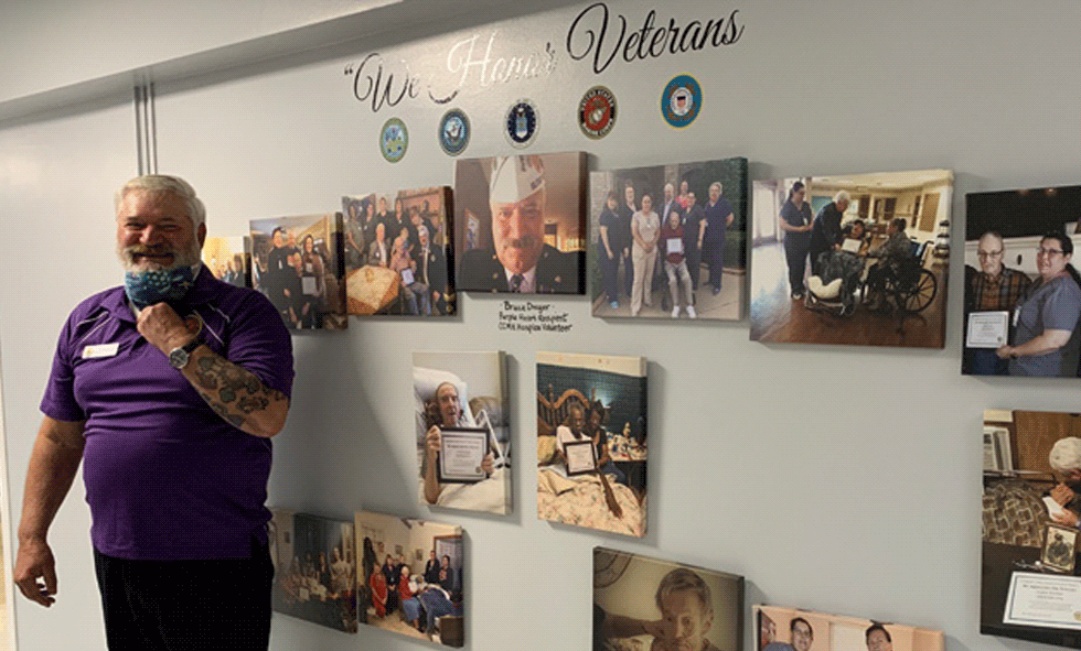 CCMH Hospice Volunteer in front of new We Honor Veterans wall