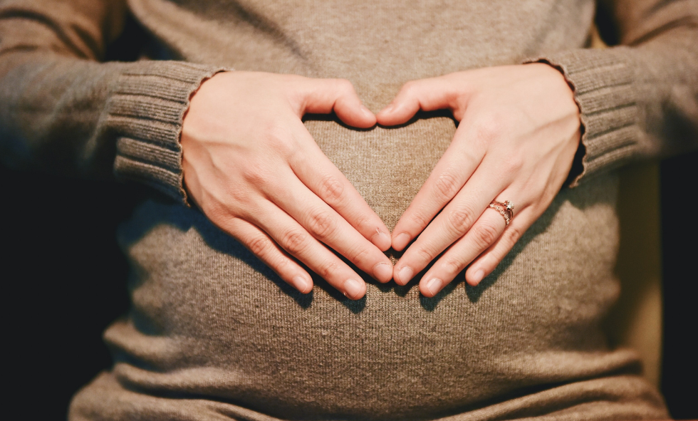 pregnant mother forming heart over belly