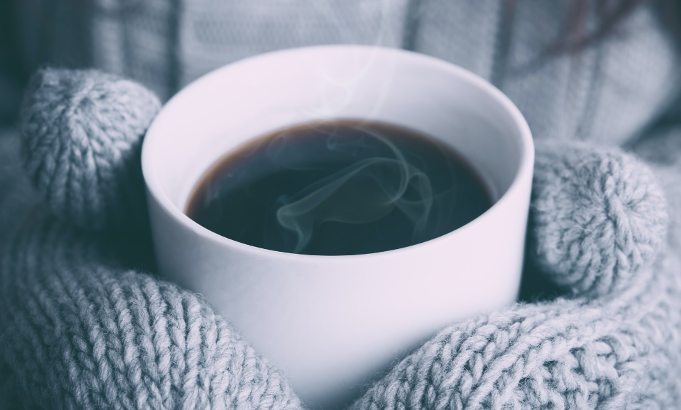 Winter Weather Safety - woman holding a cup of coffee with mittens