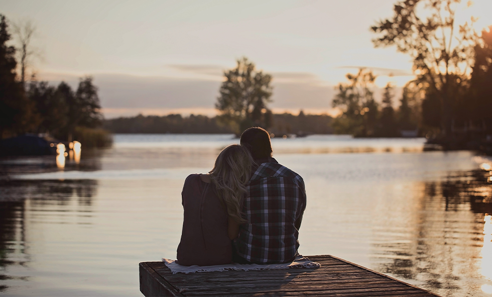 couple sitting near lake