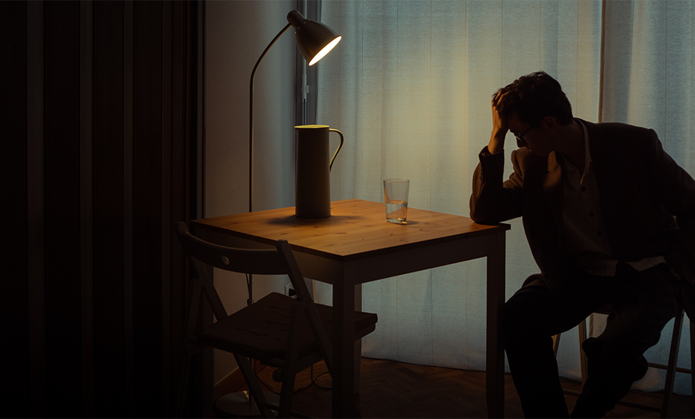 Man sitting at a desk in the dark
