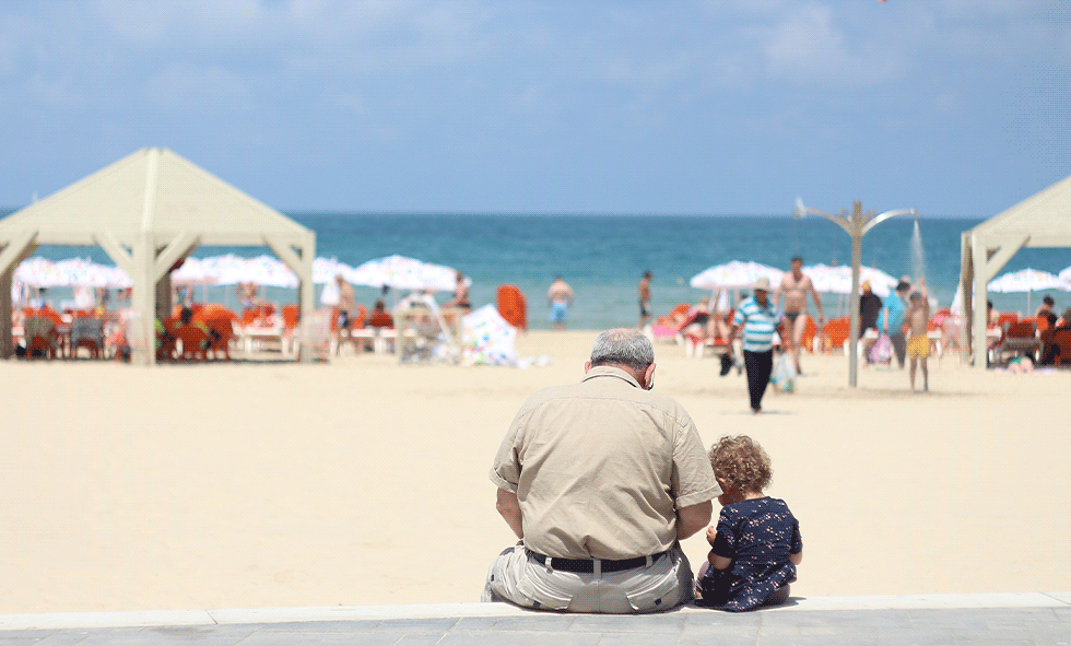 man sitting on beach with child