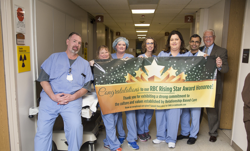 CCMH team members holding banner