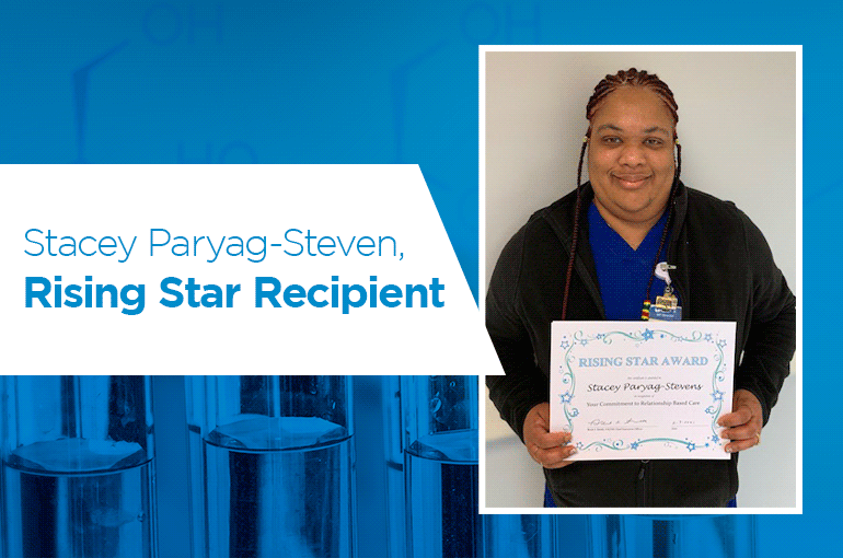 Stacey Paryag-Stephen, a smiling Black woman with braided hair, holding a Rising Star Award