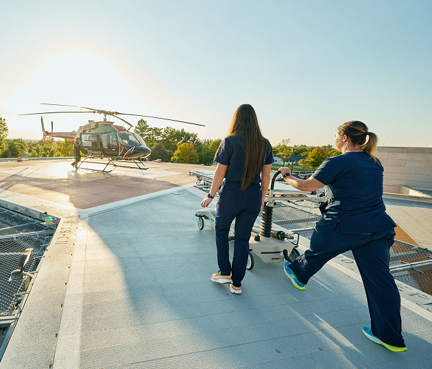 Two nurses with gurney heading towards helicopter on rooftop Two nurses with gurney heading towards helicopter on rooftop