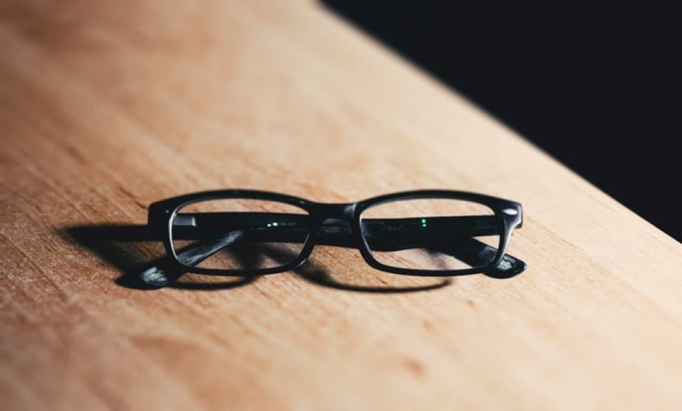 black glasses used for good eye health sitting on wood table